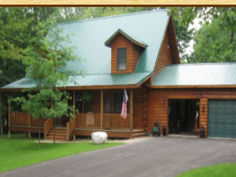 Custom log home with a metal roof, dormer, and attached garage